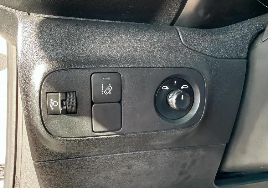 Détail des commandes noires sur panneau intérieur côté gauche d'une Citroën C3 blanche de 2017.