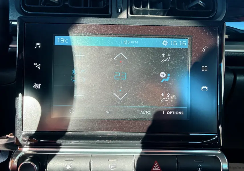 Écran tactile central de la Citroën C3 blanc, affichant la climatisation à 23°C en vue frontale rapprochée.