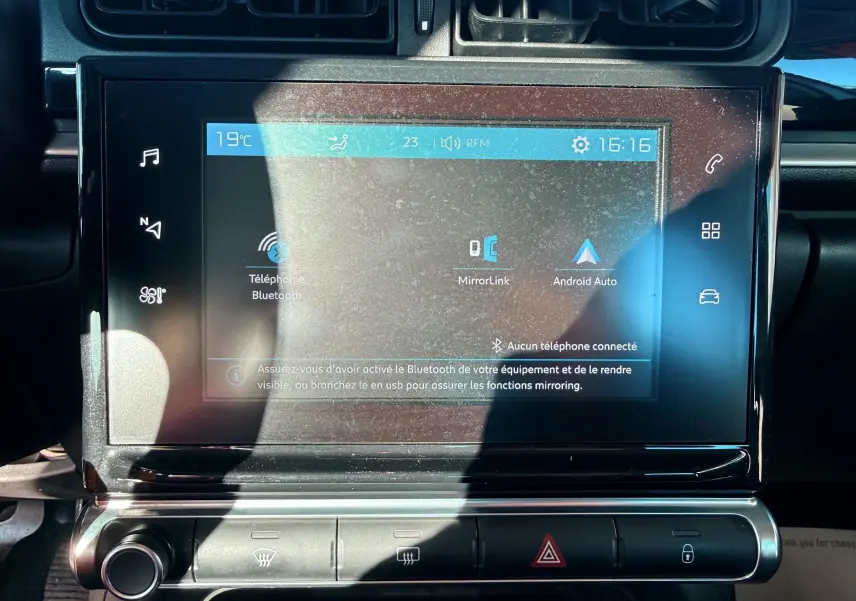 Gros plan sur l’écran tactile central du tableau de bord de la Citroën C3 blanc, affichant les options Bluetooth et Android Auto.