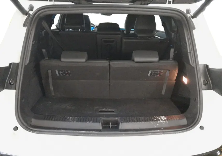 Vue arrière du coffre ouvert du Renault Espace blanc nacré, montrant la banquette arrière en position relevée.