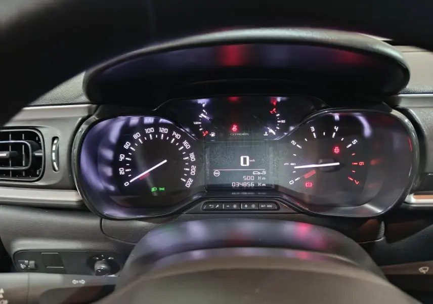 Vue rapprochée du tableau de bord de la Citroën C3 gris clair 2024, affichage numérique et compteurs analogiques éclairés.