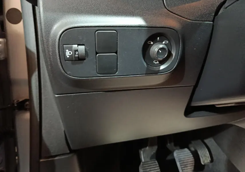 Détail du panneau de réglage des phares et des rétroviseurs côté conducteur dans l’habitacle gris foncé d’une Citroën C3 2024.