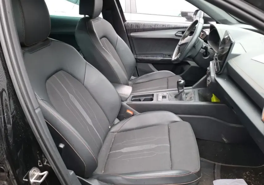 Vue intérieure côté conducteur du CUPRA Formentor 2.0 TDI noir, sièges tissu noir avec surpiqûres cuivrées et tableau de bord moderne.