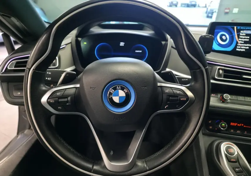 Vue rapprochée du volant cuir noir de la BMW i8 Pure Impulse 2015 avec tableau de bord numérique et écran central.