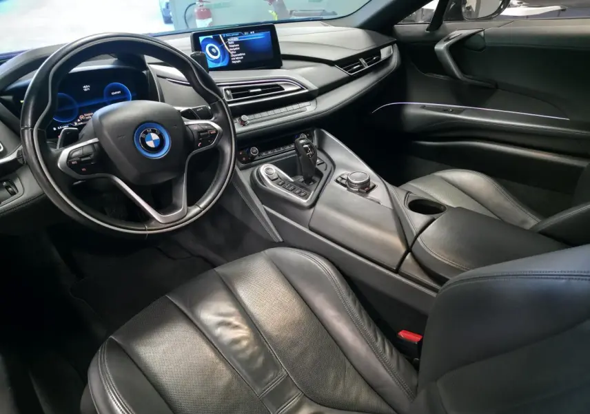 Intérieur noir de la BMW i8 Coupé Pure Impulse 2015, vue côté conducteur avec tableau de bord numérique et console centrale moderne.