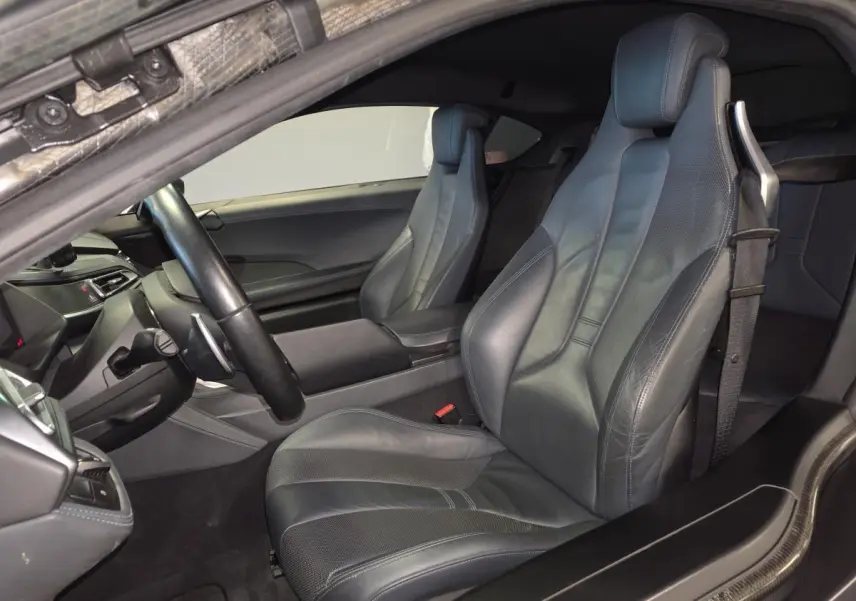 Vue intérieure côté conducteur de la BMW i8 Coupé Pure Impulse 2015 avec sièges sport en cuir gris et détails carbone.