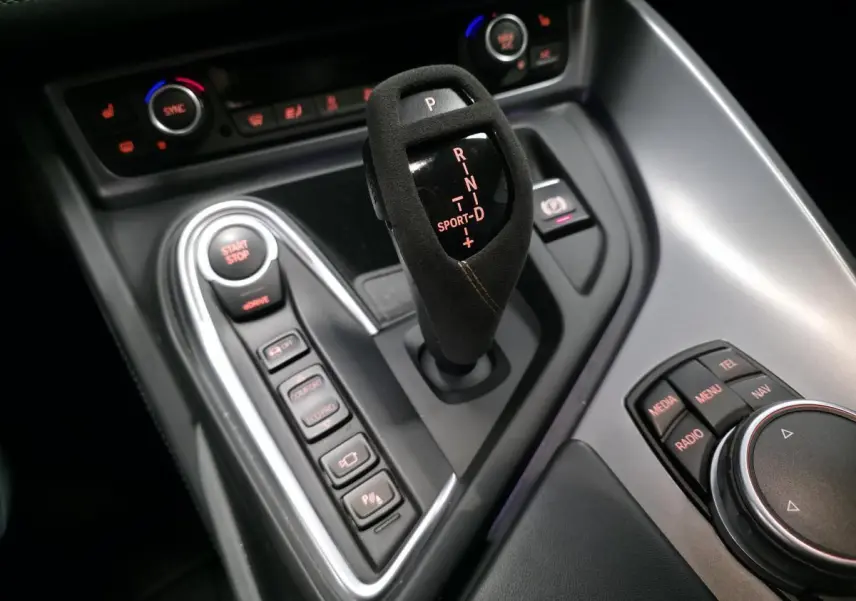 Gros plan sur la console centrale noire du BMW i8 Coupé Pure Impulse avec levier de vitesses en alcantara et commandes de mode de conduite.