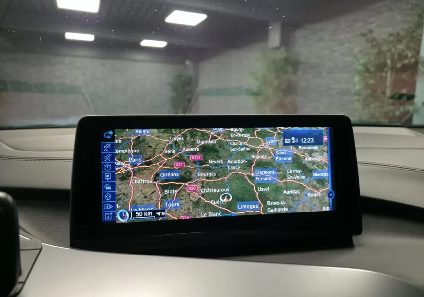 Écran de navigation multimédia affichant une carte routière dans l'habitacle d'une BMW i8 noire.