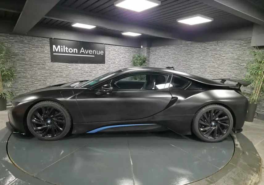 BMW i8 Coupé Pure Impulse noir mat vue de profil côté gauche avec jantes noires et spoiler arrière.