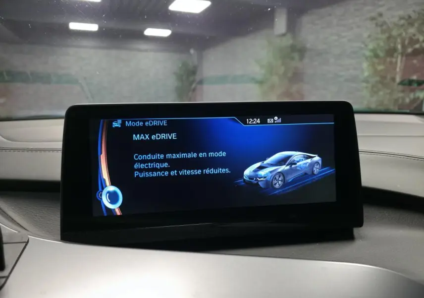 Écran central intérieur affichant le mode eDrive avec illustration d'une BMW i8 en bleu sur fond noir.