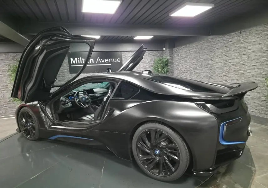 BMW i8 Coupé Pure Impulse noir mat vue 3/4 arrière droit avec portes en élytre ouvertes et jantes 20 pouces.