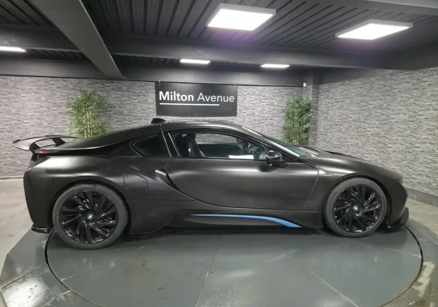 BMW i8 Coupé Pure Impulse noir mat, vue de profil côté gauche avec jantes turbine 20 pouces et détails bleus.