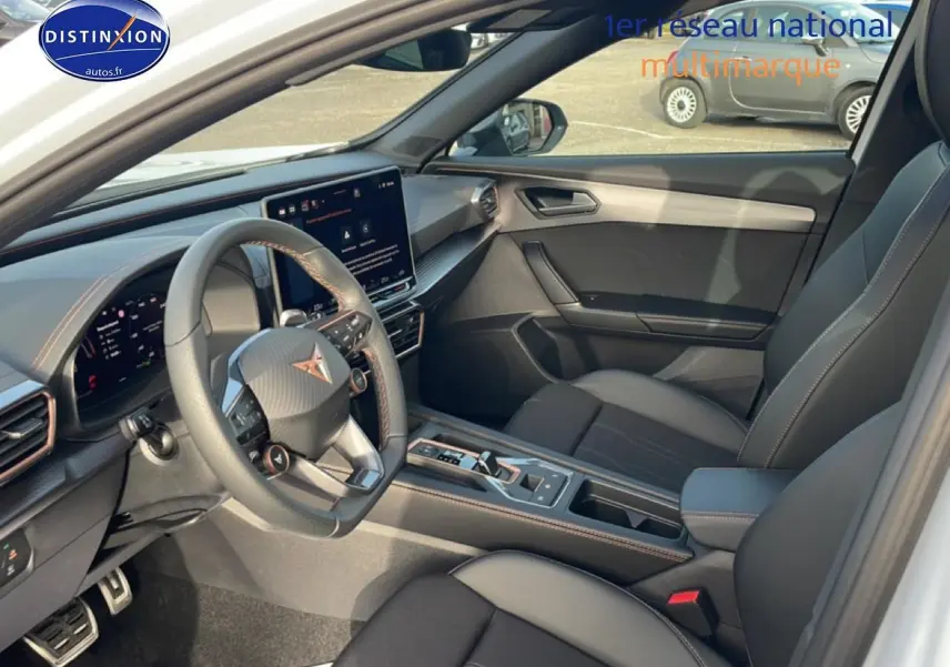 Vue intérieure côté conducteur de la CUPRA Formentor blanc Nevada, avec volant cuir sport et écran tactile central.