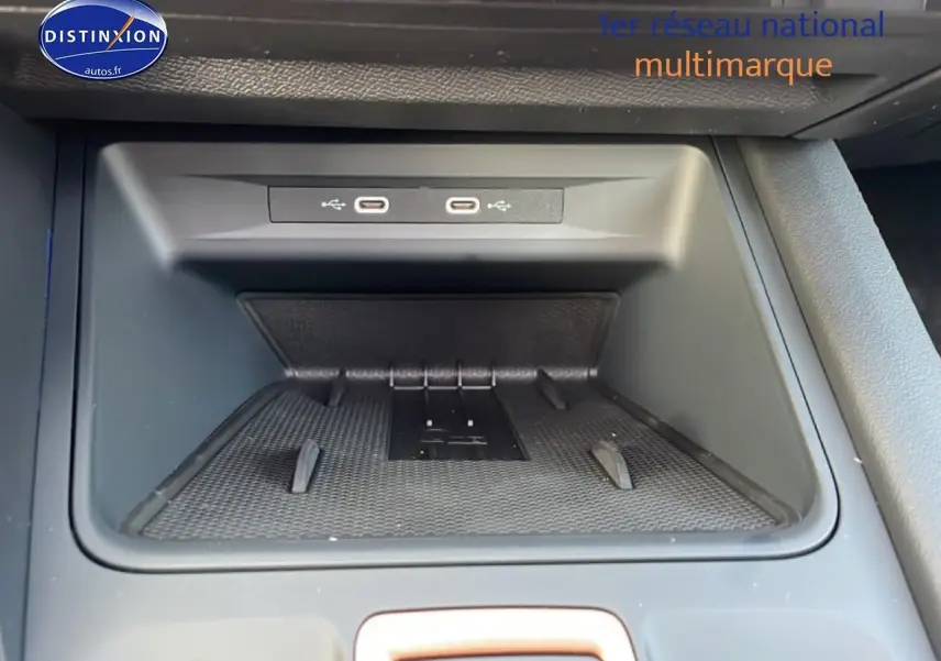 Gros plan sur le rangement central avant avec ports USB-C dans l'habitacle noir du CUPRA Formentor blanc Nevada.