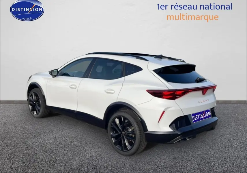 Vue 3/4 arrière droite d'un CUPRA Formentor blanc Nevada avec jantes noires et vitres arrière surteintées.