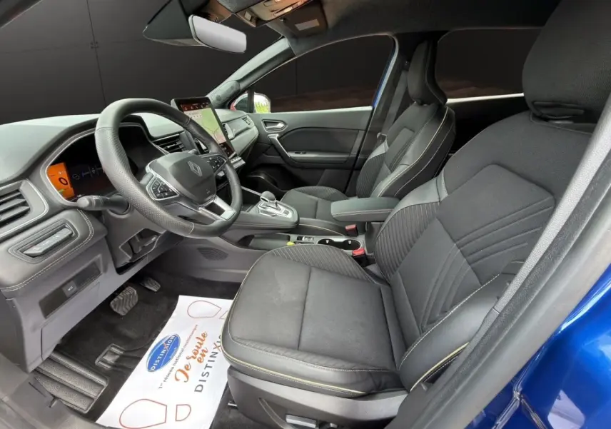 Vue intérieure côté conducteur de la Renault Symbioz Iconic E-Tech bleu, avec sièges noirs et tableau de bord digital.