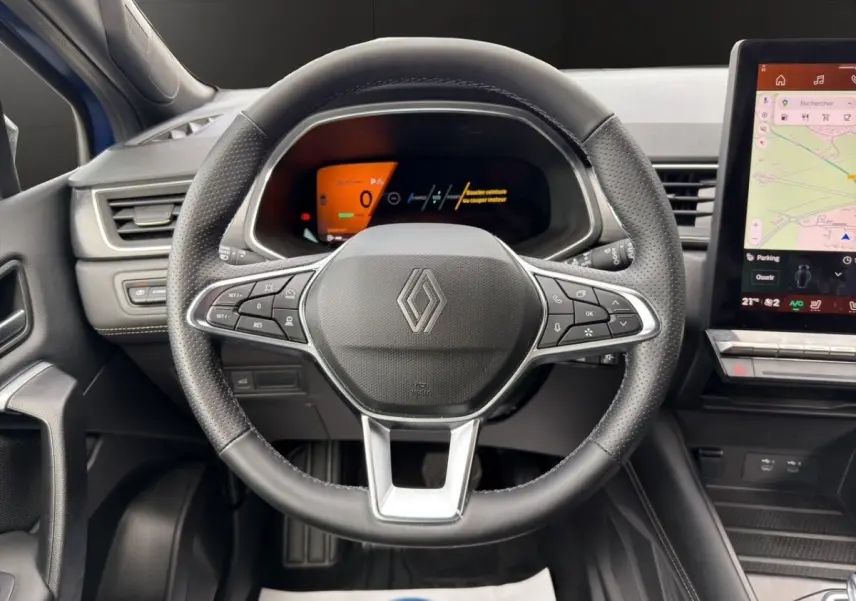 Vue rapprochée du volant noir en cuir avec commandes multifonctions et tableau de bord numérique du Renault Symbioz.