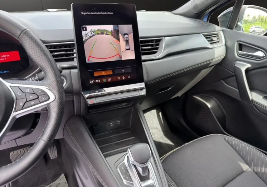 Intérieur Renault Symbioz bleu, vue côté passager montrant écran tactile central et levier de boîte automatique.