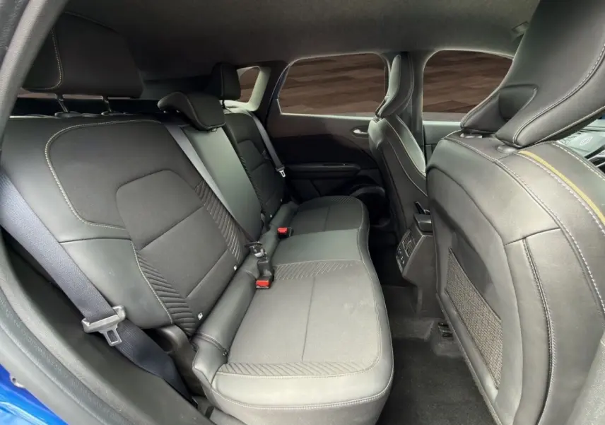 Vue intérieure côté droit sur la banquette arrière noire du Renault Symbioz bleu, avec appuie-têtes et ceintures visibles.