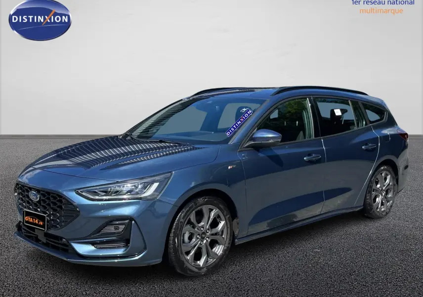 Ford Focus SW bleu en 3/4 avant droit, break ST Line X avec jantes alliage et calandre noire distinctive.