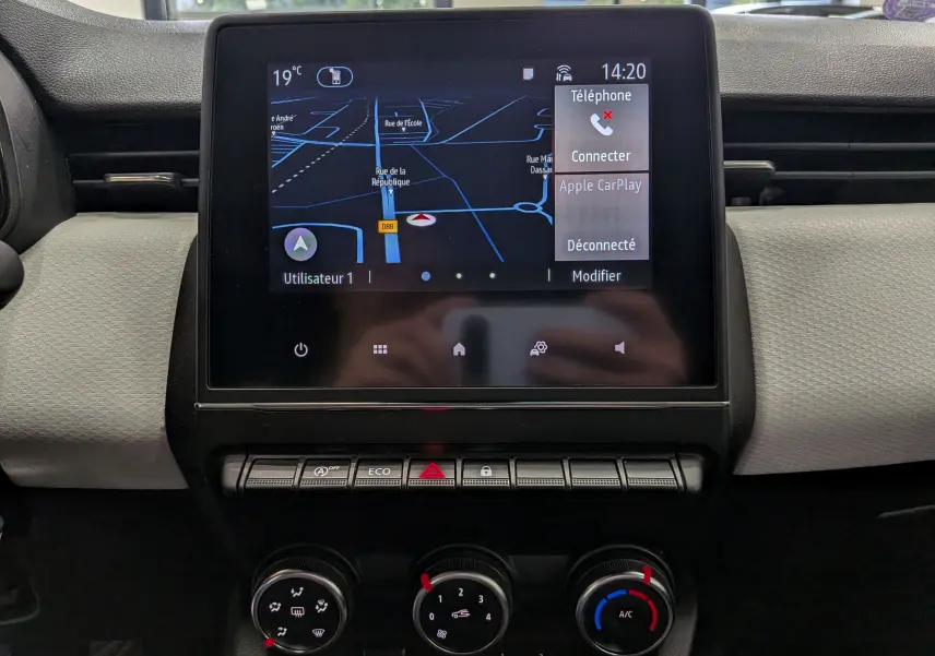 Vue rapprochée de l’écran tactile central de la Renault Clio V blanc Glacier, affichant la navigation et options connectivité.