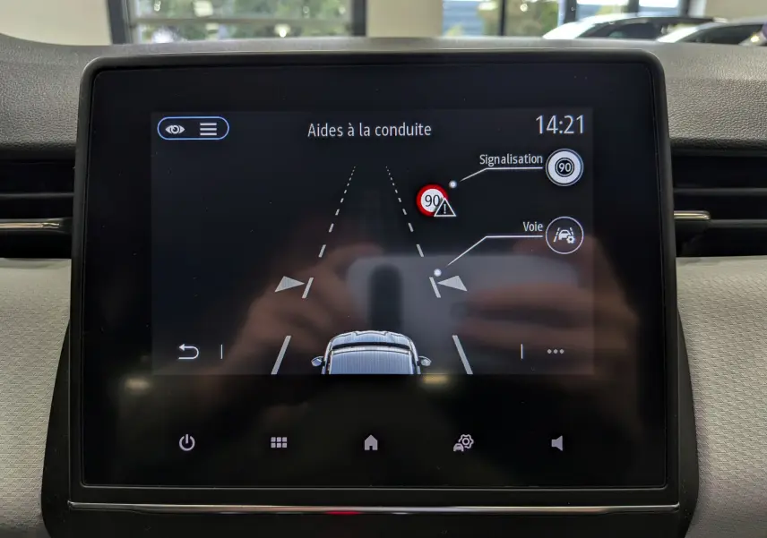Écran tactile intérieur montrant l'aide à la conduite avec signalisation et détection de voie sur Renault Clio V blanc Glacier.
