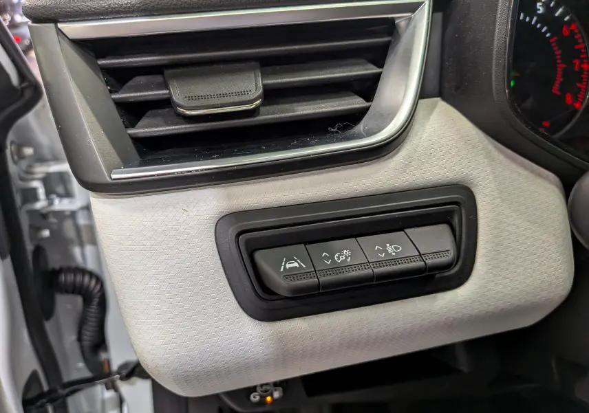 Détail intérieur côté gauche du tableau de bord blanc glacier de la Renault Clio V avec commandes d'assistance à la conduite.