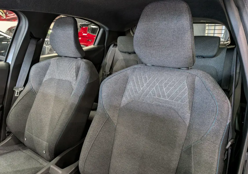 Vue intérieure rapprochée des sièges avant en tissu gris de la Renault Clio VI 1.2 TCe 115 Evolution 2026.