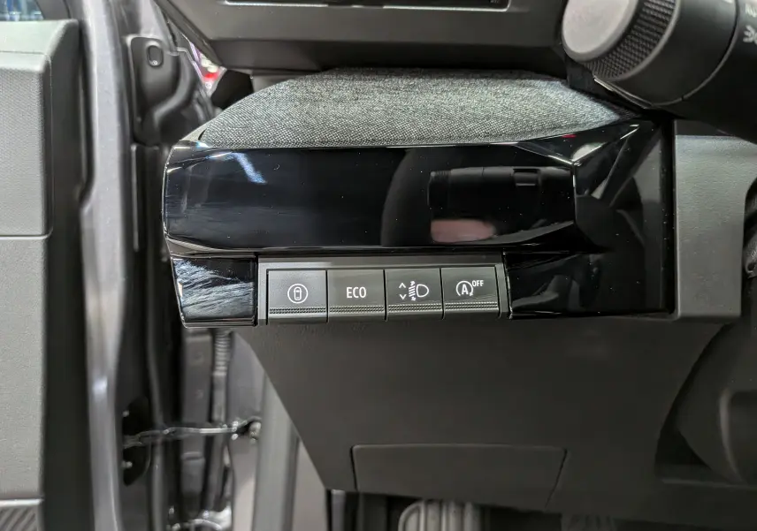 Vue rapprochée des commandes côté gauche du tableau de bord d’une Renault Clio VI gris schiste, boutons ECO et aides à la conduite.