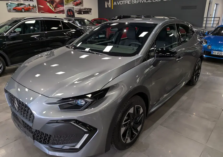 Renault Clio VI gris schiste vue 3/4 avant droit, avec jantes bi-ton et phares LED au design anguleux.