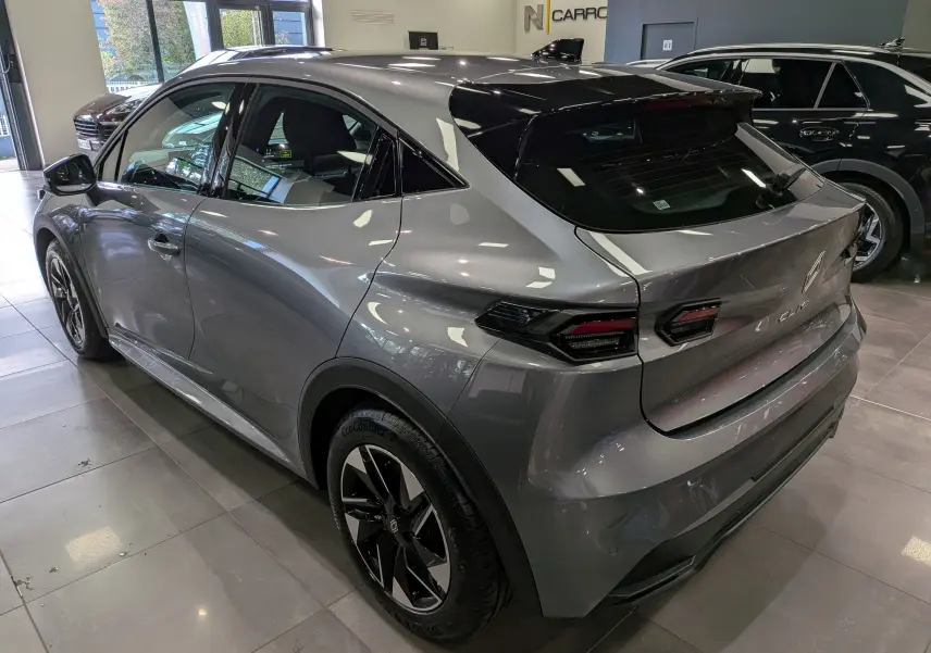 Vue 3/4 arrière droit de la Renault Clio VI gris schiste avec feux arrière LED et jantes bi-ton en concession.