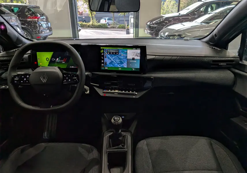 Vue intérieure frontale de la Renault Clio VI 1.2 TCe 115 Evolution avec tableau de bord numérique et écran tactile central.