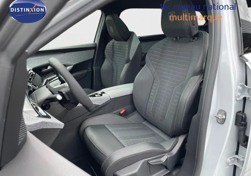 Vue intérieure côté conducteur du Peugeot 5008 Hybrid 2025 avec sièges en cuir noir et tissu gris, tableau de bord moderne.