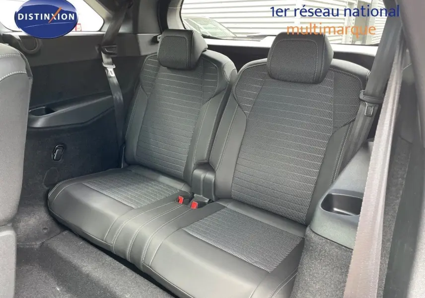 Vue intérieure sur la troisième rangée de sièges en cuir noir du Peugeot 5008 Hybrid 2025, avec ceintures visibles.