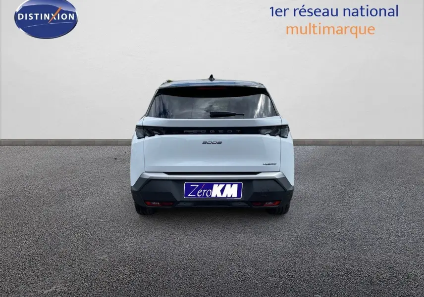 Vue arrière d'un Peugeot 5008 Hybrid blanc Okenite métal avec toit noir, modèle 2025, sur sol gris.