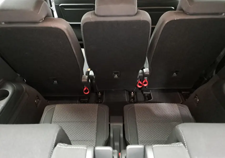 Vue intérieure arrière du Volkswagen Touran 2025, montrant les sièges noirs et les appuie-têtes de la troisième rangée.