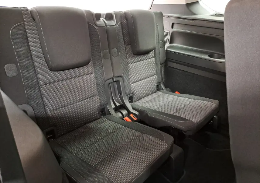 Vue intérieure sur la troisième rangée de sièges en tissu gris du Volkswagen Touran 2025, version 7 places.