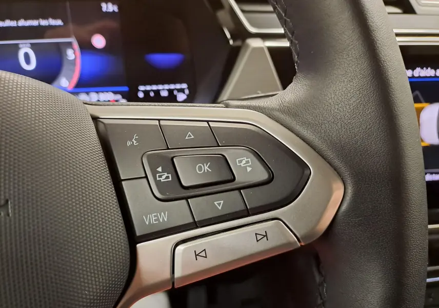 Gros plan sur les commandes multifonctions à gauche du volant du Volkswagen Touran 2025, finition VW Edition.
