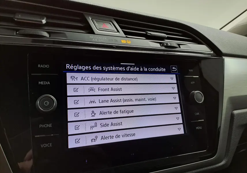 Écran tactile intérieur du Volkswagen Touran 2025 affichant les réglages des aides à la conduite.