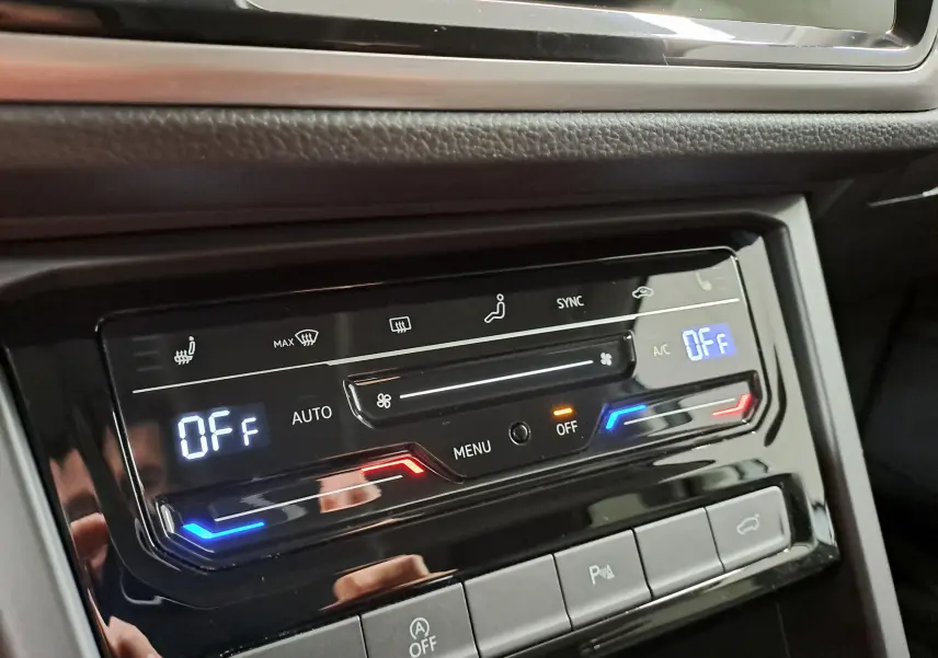 Gros plan sur la commande de climatisation digitale du Volkswagen Touran 2025, avec affichage des réglages et boutons tactiles.