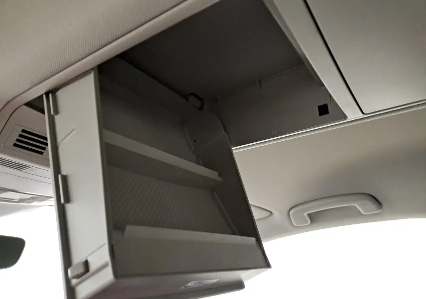 Rangement plafond ouvert dans l'habitacle clair du Volkswagen Touran 2025, vue intérieure rapprochée.
