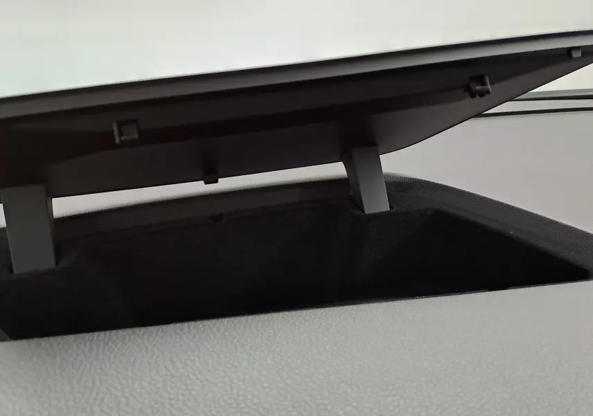 Coffre de rangement ouvert sur le tableau de bord du Volkswagen Touran 2025 en Argent Dolomite, vue intérieure rapprochée.