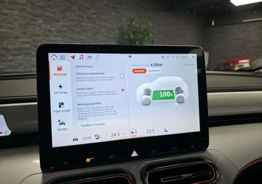 Écran tactile central du tableau de bord d'une Smart Electric blanche, affichant la recharge à 100% et 439 km d'autonomie.