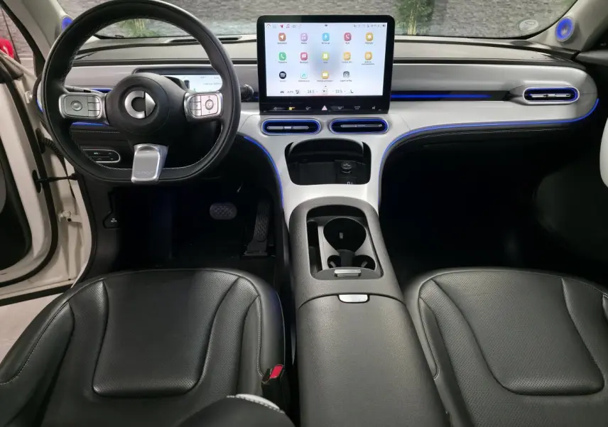 Vue intérieure avant du Smart #1 électrique blanc 2024, avec tableau de bord moderne et écran tactile central lumineux.