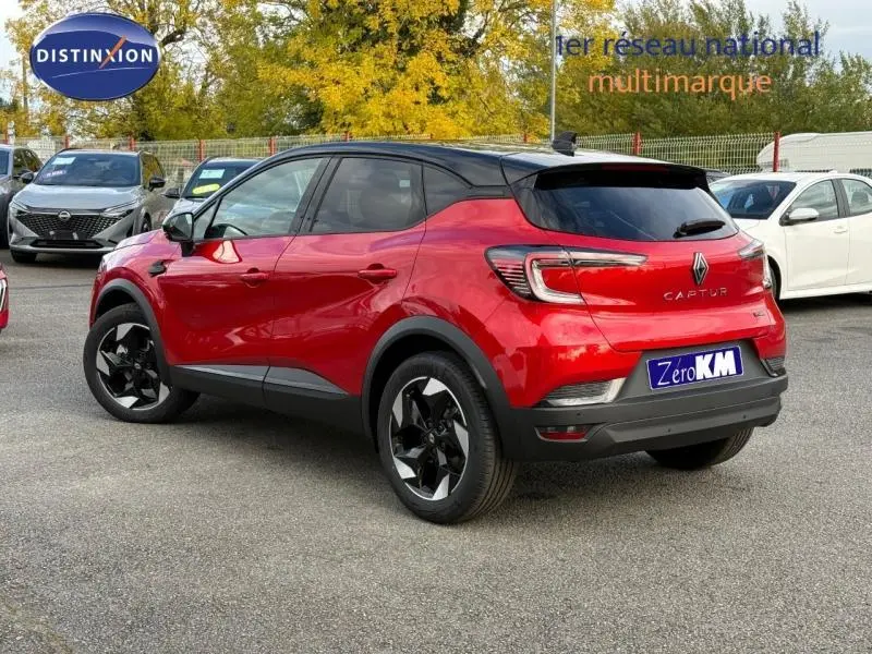 Renault Captur 2025 rouge flamme en vue 3/4 arrière droit, toit noir contrasté et jantes noires distinctives.