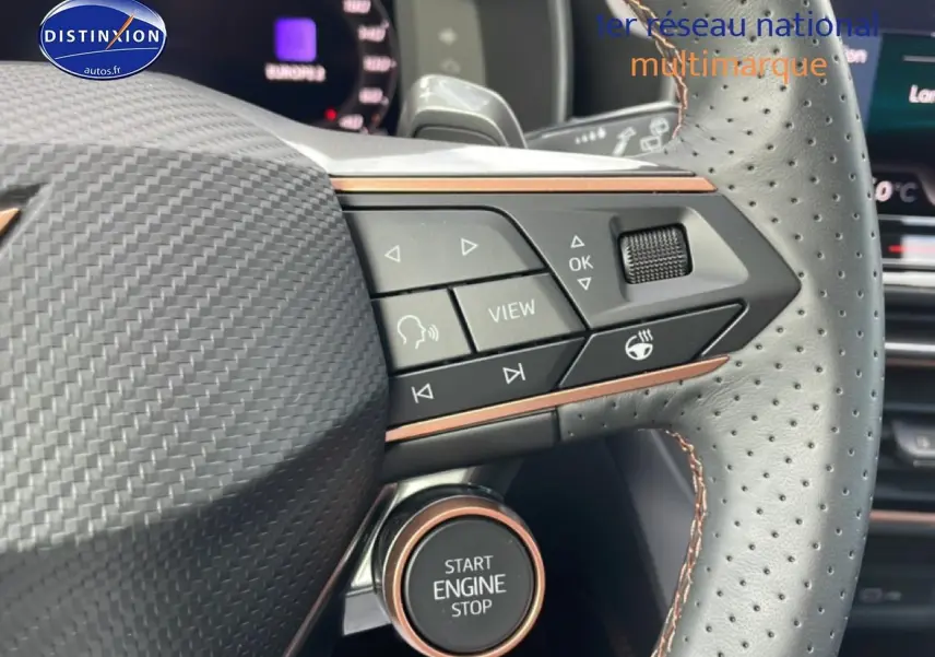 Gros plan sur le volant cuir perforé du Cupra Formentor gris magnétique, avec commandes multifonctions et bouton start/stop visible.