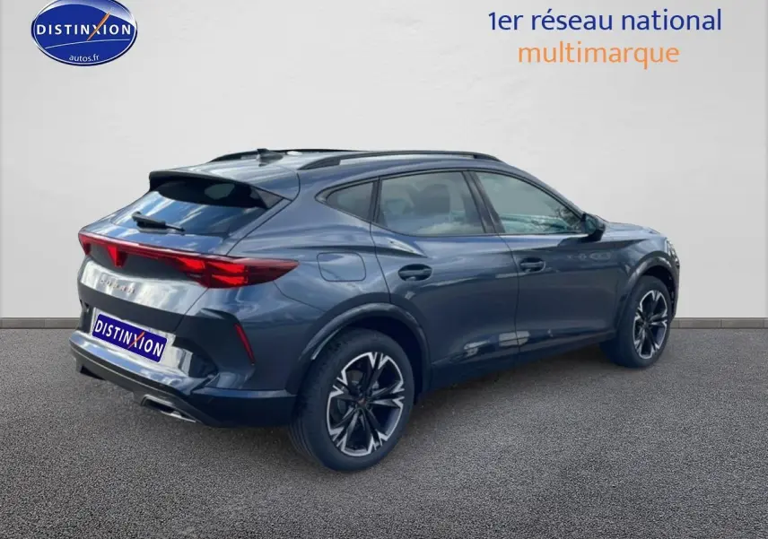 Vue 3/4 arrière droite d'un CUPRA Formentor gris magnétique avec jantes noires et feux arrière LED allumés.