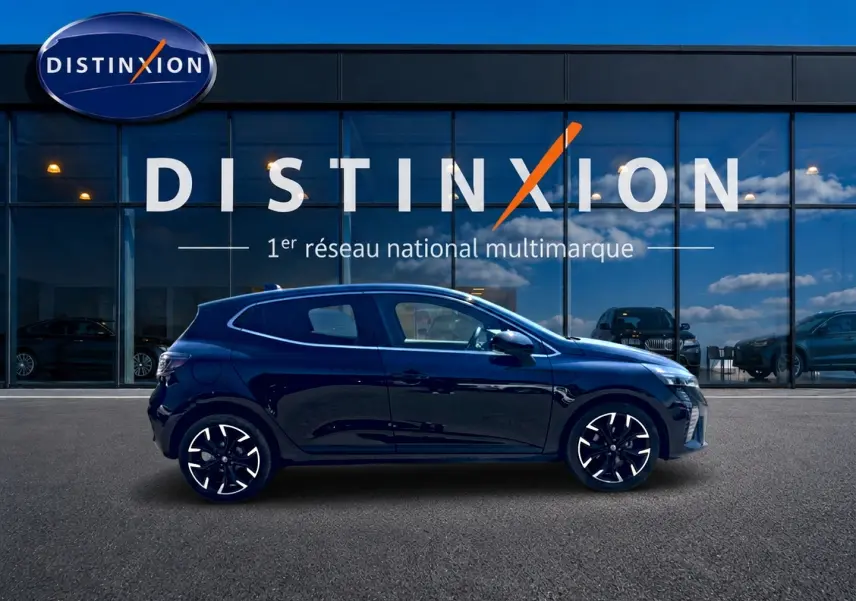 Profil droit d'une Renault Clio V noire 2025, avec jantes alliage et lignes épurées, devant une vitrine Distinxion.