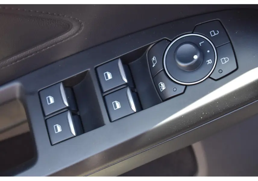 Gros plan sur les commandes des vitres et des rétroviseurs côté conducteur de la Ford Focus SW 2025 finition ST LINE X.
