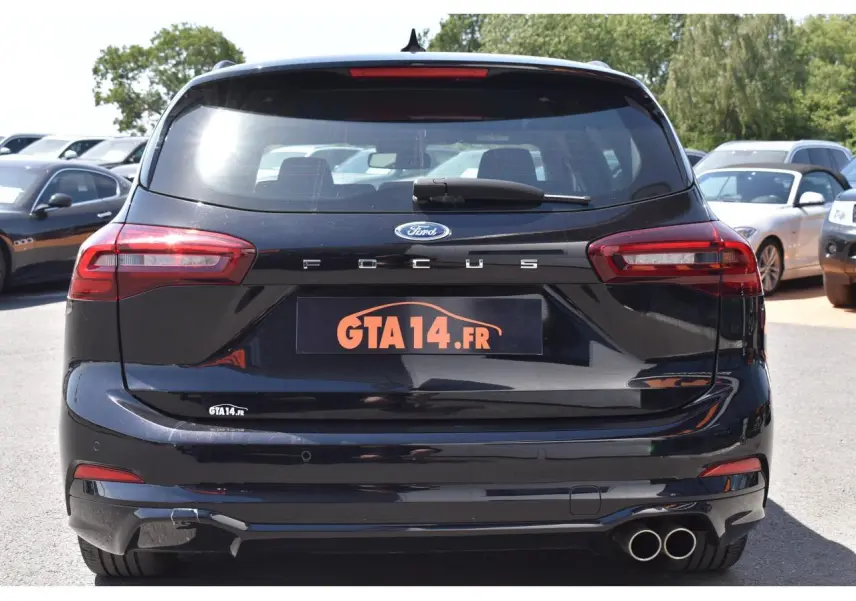 Vue arrière d'une Ford Focus SW 2025 Agate Black Metallic avec double sortie d'échappement et feux LED distinctifs.